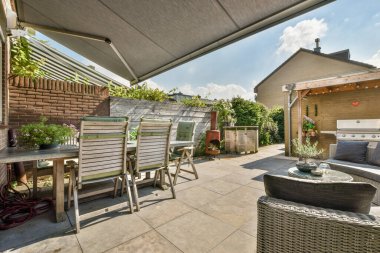 Neat powerful patio with sitting area and small garden near wooden fence