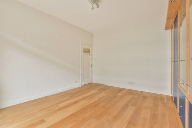 Dolaplı ve parke zeminli geniş balkon pencereli boş beyaz odanın içi