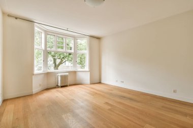 Parke ve radyatörlü pencereli boş beyaz odanın içi