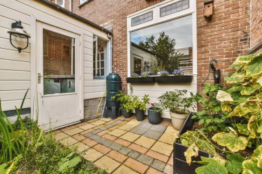 Oturma alanı ve ahşap çitlerin yanındaki küçük bahçesi olan düzgün asfaltlı bir avlu.