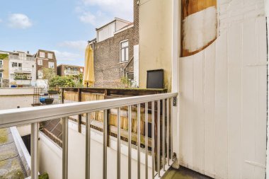 Eski tuğlalı binaların ve bisikletli arabaların ön manzarası küçük balkondan tırabzanlara kadar uzanıyor.