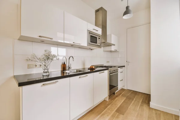 Minimalist Tarzı Beyaz Mobilyalı Lavabolu Sobalı Bir Mutfağı — Stok fotoğraf