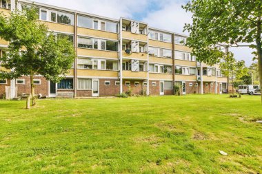 Arabaları, ağaçları ve fenerleri olan boş bir kaldırımdan panorama manzaralı evler.