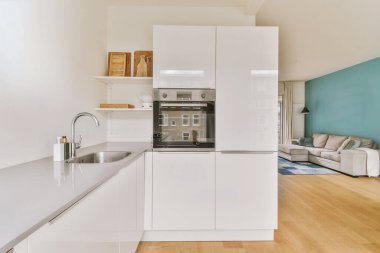 Minimalist tarzı beyaz mobilyalı, lavabolu ve sobalı bir ev mutfağı.