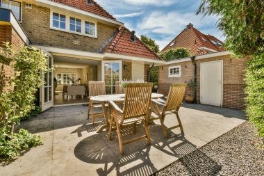 Neat powerful patio with sitting area and small garden near wooden fence