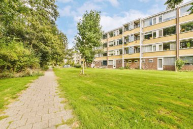 Arabaları, ağaçları ve fenerleri olan boş bir kaldırımdan panorama manzaralı evler.