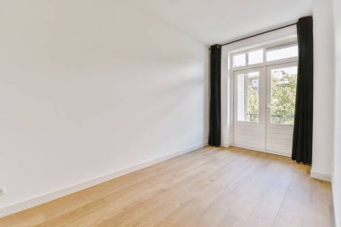 Evdeki boş ışık odasında, beyaz duvardaki plastik pencere ve radyatör.