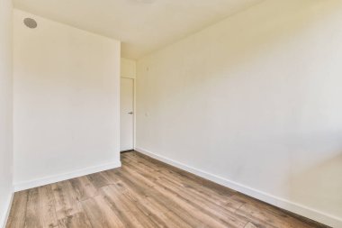 Evdeki boş ışık odasında, beyaz duvardaki plastik pencere ve radyatör.