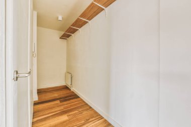 Dar, boş koridor lambalarla aydınlatılmış, minimal tarzda modern dairenin içi