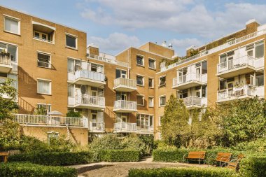 Ağaçlar ve fenerlerle dolu boş bir kaldırım sokağından tuğla evler manzarası