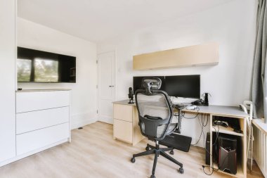 Boş tahtaya karşı bilgisayar monitörleri olan rahat sandalye ve çağdaş düz ev ofisinde ayna