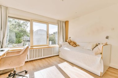 Yatak odasının iç tasarımı, yatak odası ve ahşap gardırop modern dairenin penceresinin kenarına yerleştirilmiş.