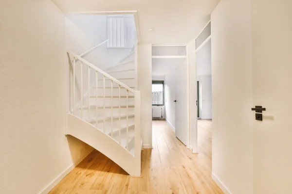 stock image White hallway with wooden stairway leading to second floor of modern luxury apartment with minimalist interior design