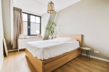 Yatak odasının iç tasarımı, yatak odası ve ahşap gardırop modern dairenin penceresinin kenarına yerleştirilmiş.