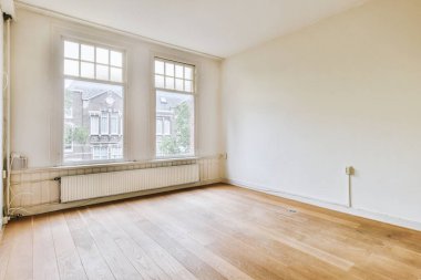 Evdeki boş ışık odasında, beyaz duvardaki plastik pencere ve radyatör.