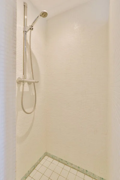 玻璃隔板附近贴在瓷墙上的淋浴水龙头 以及家中卫生间的装饰品 — 图库照片