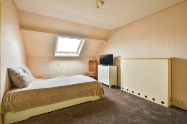 Küçük Mansard yatak odasının ev tasarımı yumuşak rahat yatağı ve gündüz aydınlatmalı minimalist tarzı rafları var.