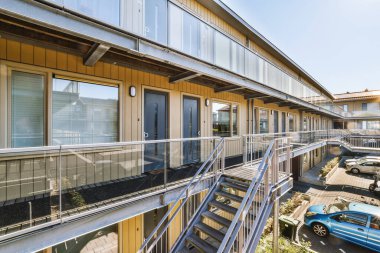 Dar koridorun içinde bir sürü kapı ve beyaz duvarlarda klasik resim var.