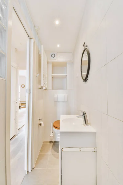 現代のアパートの小さなタイル張りのバスルームでシンクとシャワーの間に位置するフラッシュトイレ — ストック写真