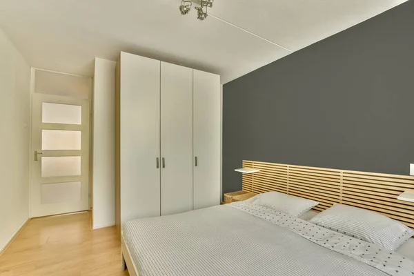 Komfortabel Seng Med Tæppe Placeret Nær Vindue Garderobe Lys Soveværelse - Stock-foto