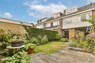 Oturma alanı ve ahşap çitlerin yanındaki küçük bahçesi olan düzgün asfaltlı bir avlu.