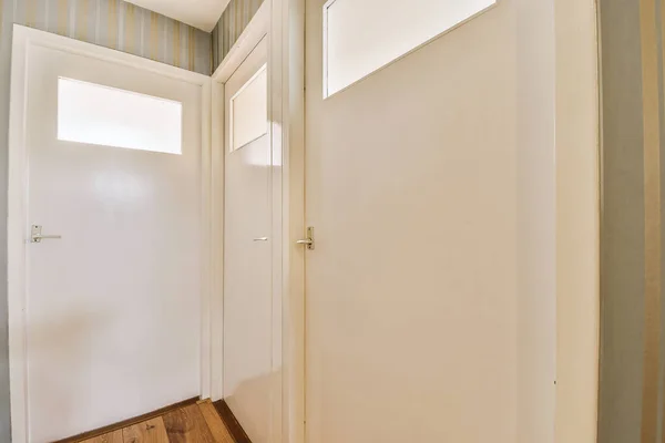 Φως Στενό Διάδρομο Πολλές Πόρτες Λευκούς Τοίχους Και Λαμπερό Λαμπτήρα — Φωτογραφία Αρχείου