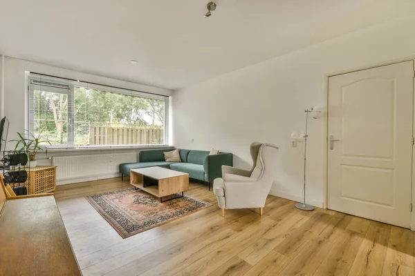 Modern apartman dairesinde, rahat kanepenin yanındaki tahta masa, televizyon, piyano ve gitarlarla donatılmış.