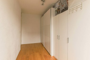 Beyaz gardırop, evdeki aydınlık odada dolabın yanında.