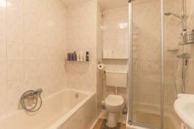 Modern apartmanda banyo küveti ve beyaz tuvaleti olan şık bir banyo tasarımı.