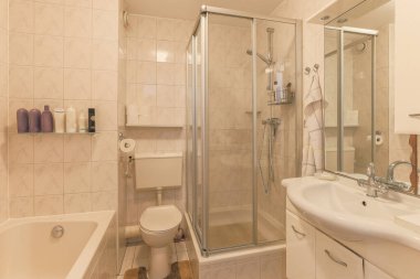 Modern apartmanda banyo küveti ve beyaz tuvaleti olan şık bir banyo tasarımı.