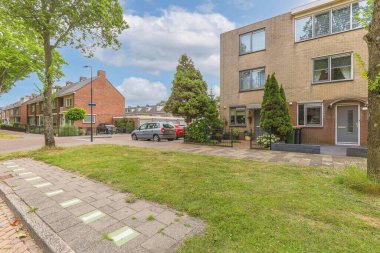 Boş bir kaldırım sokağından panorama manzaralı evler arabalar, ağaçlar ve fenerler