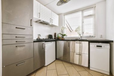 Minimalist tarzı beyaz mobilyalı, lavabolu ve sobalı bir ev mutfağı.