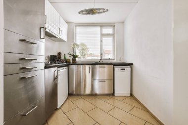 Minimalist tarzı beyaz mobilyalı, lavabolu ve sobalı bir ev mutfağı.