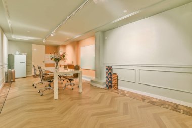 Çağdaş dairenin dinlenme odasının yakınındaki sandalyeli ve çiçekli masa