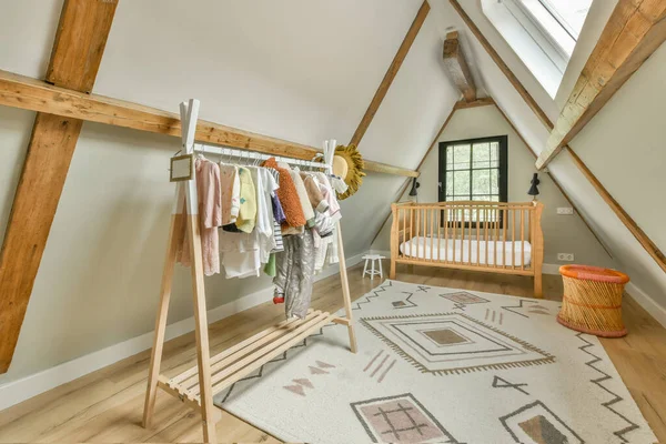 白屋室内 有婴儿床及靠窗的扶手椅 日间装有抽屉箱 — 图库照片