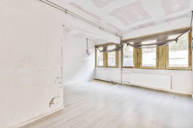 Evdeki boş ışık odasında, beyaz duvardaki plastik pencere ve radyatör.