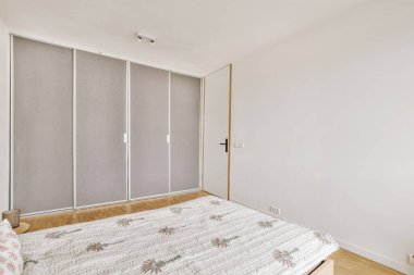 Yatak odasının iç tasarımı, yatak odası ve ahşap gardırop modern dairenin penceresinin kenarına yerleştirilmiş.