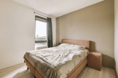 Yatak odasının iç tasarımı, yatak odası ve ahşap gardırop modern dairenin penceresinin kenarına yerleştirilmiş.