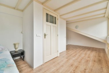 Rahat bir yatak, pencerenin yanında beyaz çarşaflar ve evde hafif mansard yatak odası.