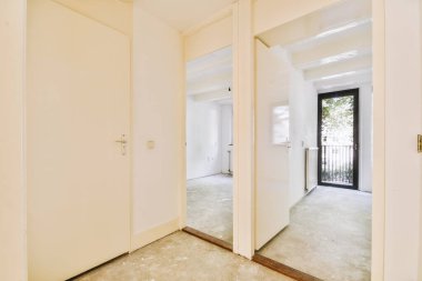 Evdeki boş ışık odasında, beyaz duvardaki plastik pencere ve radyatör.