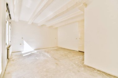 Evdeki boş ışık odasında, beyaz duvardaki plastik pencere ve radyatör.