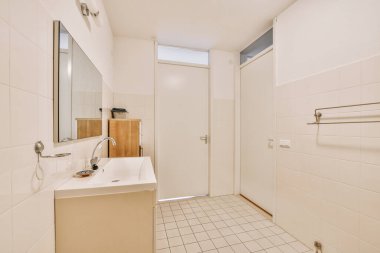 Sinks with mirrors and shower box with glass door in modern bathroom with white tiled walls