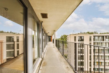 Eski tuğla binaların panoramik manzarası. Küçük balkondan park yerleri ve ağaçlar.