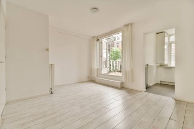 Evdeki boş ışık odasında, beyaz duvardaki plastik pencere ve radyatör.