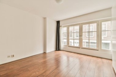 Evdeki boş ışık odasında, beyaz duvardaki plastik pencere ve radyatör.