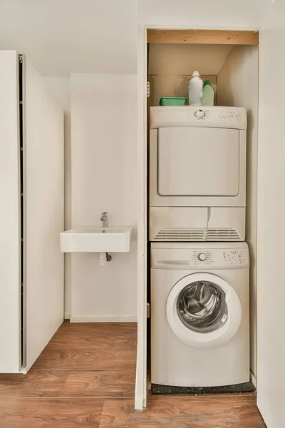 stock image Laundry room in light bathroom with washing machine and with white walls and dark reflect floor