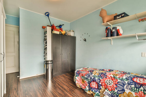 Дизайн интерьера спальни с кроватью и деревянным шкафом в углу у окна в современной квартире