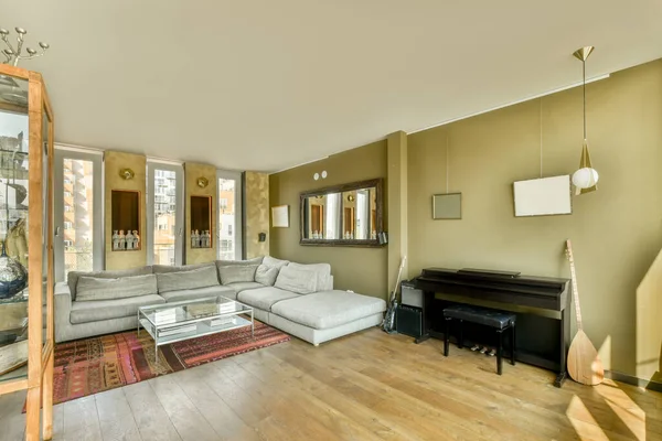 モダンなアパートメントでスタイリッシュな装飾が施された広々とした部屋にある椅子と快適なソファ付きのテーブル — ストック写真
