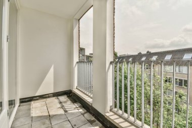 Küçük balkondan ağaçlı tuğla binaların panoramik manzarası