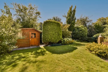 Neat paved patio with sitting area and small garden near wooden fence